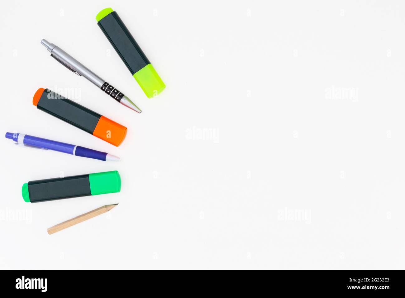 Evidenziatori gialli, verdi e arancioni, una matita e due penne a sfera su  sfondo bianco Foto stock - Alamy