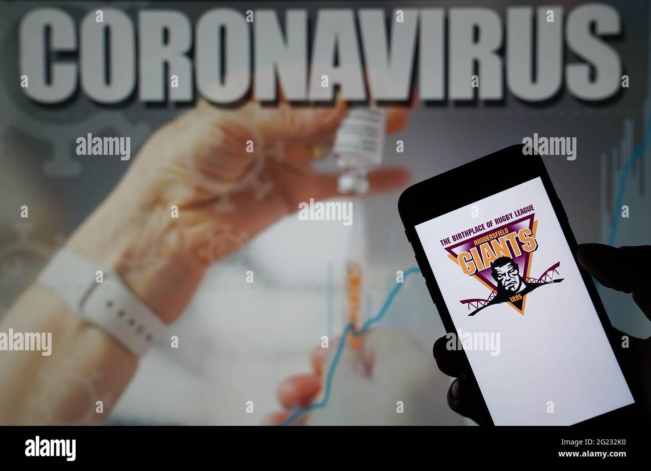 File photo datato 09-01-2021 del logo Huddersfield Giants visto su un telefono cellulare con un'illustrazione di Coronavirus su un monitor in background data di emissione: Martedì 8 giugno 2021. Foto Stock