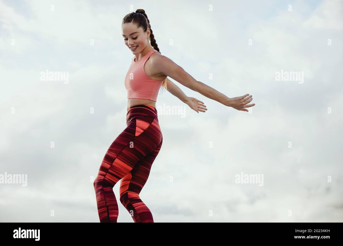 Donna sana in fitness indossare esercizio all'aperto. una donna che si sta allenando contro il cielo. Foto Stock