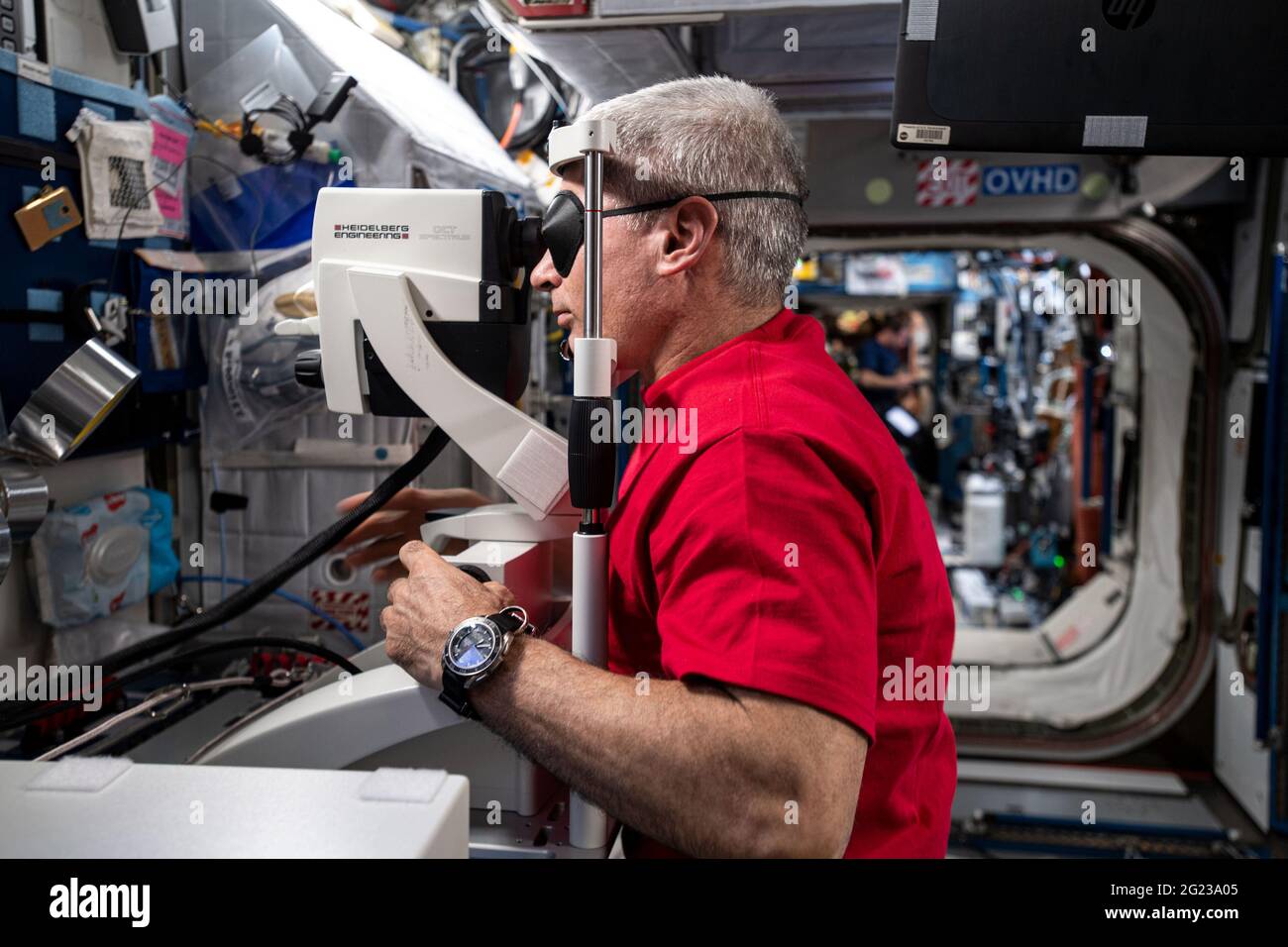 L'astronauta della NASA, Mark Vande Hei, si trova in un dispositivo di imaging medico vicino all'infrarosso, o in una tomografia a coerenza ottica, per una visione dettagliata della sua retina nell'ambito di controlli oculari programmati regolarmente a bordo della Stazione spaziale Internazionale. Gli astronauti controllano periodicamente gli occhi a causa di un fenomeno noto come sindrome neuroculare associata allo spazio (SANS). I sintomi includono gonfiore nel disco ottico, dove il nervo ottico entra nella retina e appiattimento della forma dell'occhio. Quando i ricercatori hanno guardato indietro, hanno trovato alcuni aspetti delle SAN anche nei primi spaceflight. NASA/UPI Foto Stock