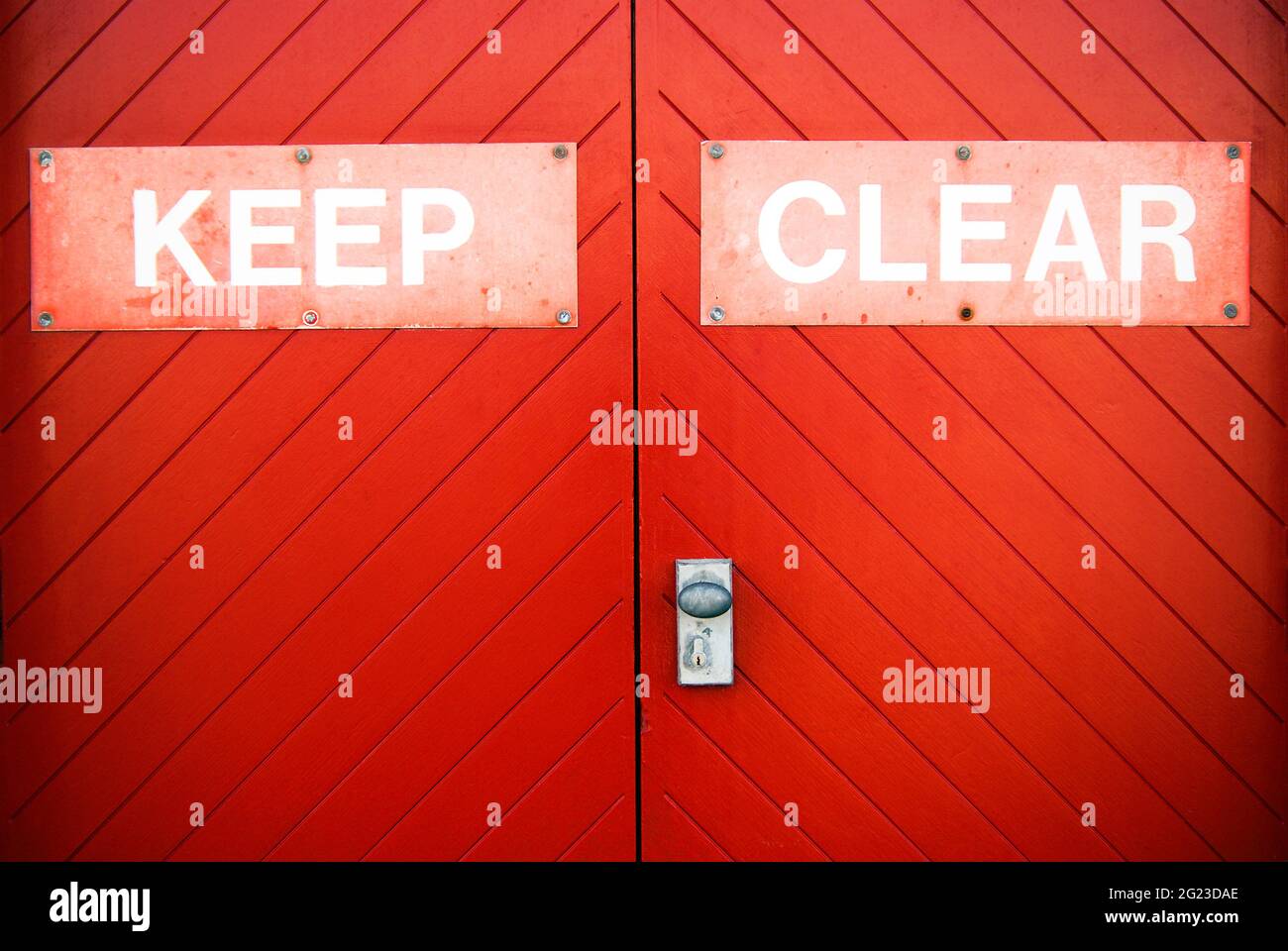 Tenere chiaro segno verniciato su una porta di legno rosso brillante garage per impedire alle persone di bloccare l'accesso. Foto Stock