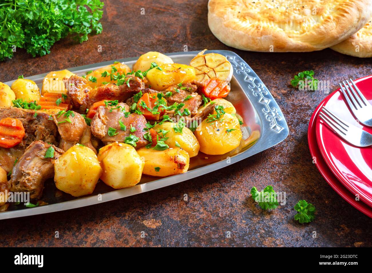 Arrostire i pezzi di tacchino con verdure servite sul vassoio di metallo con tortillas fresche. Patate con carne. Foto Stock