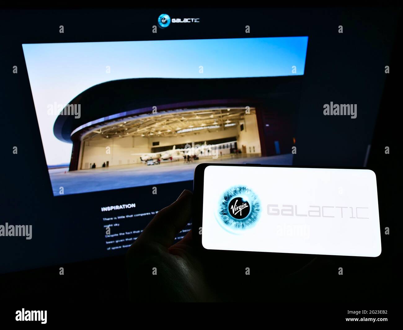 Persona che detiene smartphone con il logo della società aerospaziale americana Virgin Galactic LLC sullo schermo di fronte al sito Web aziendale. Mettere a fuoco il display del telefono. Foto Stock
