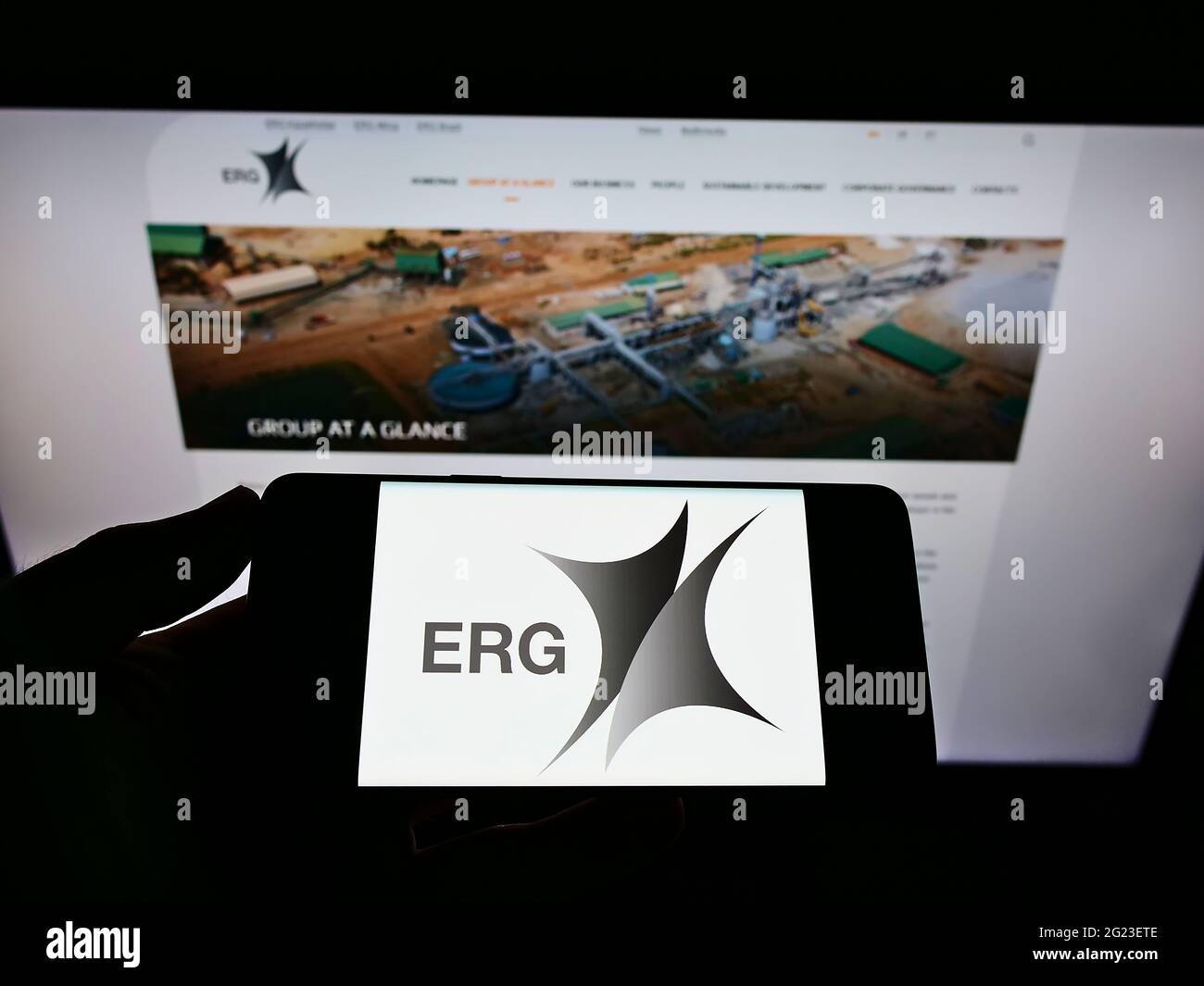 Persona che detiene il telefono cellulare con il logo della società mineraria Eurasian Resources Group (ERG) sullo schermo davanti alla pagina web. Mettere a fuoco il display del telefono. Foto Stock
