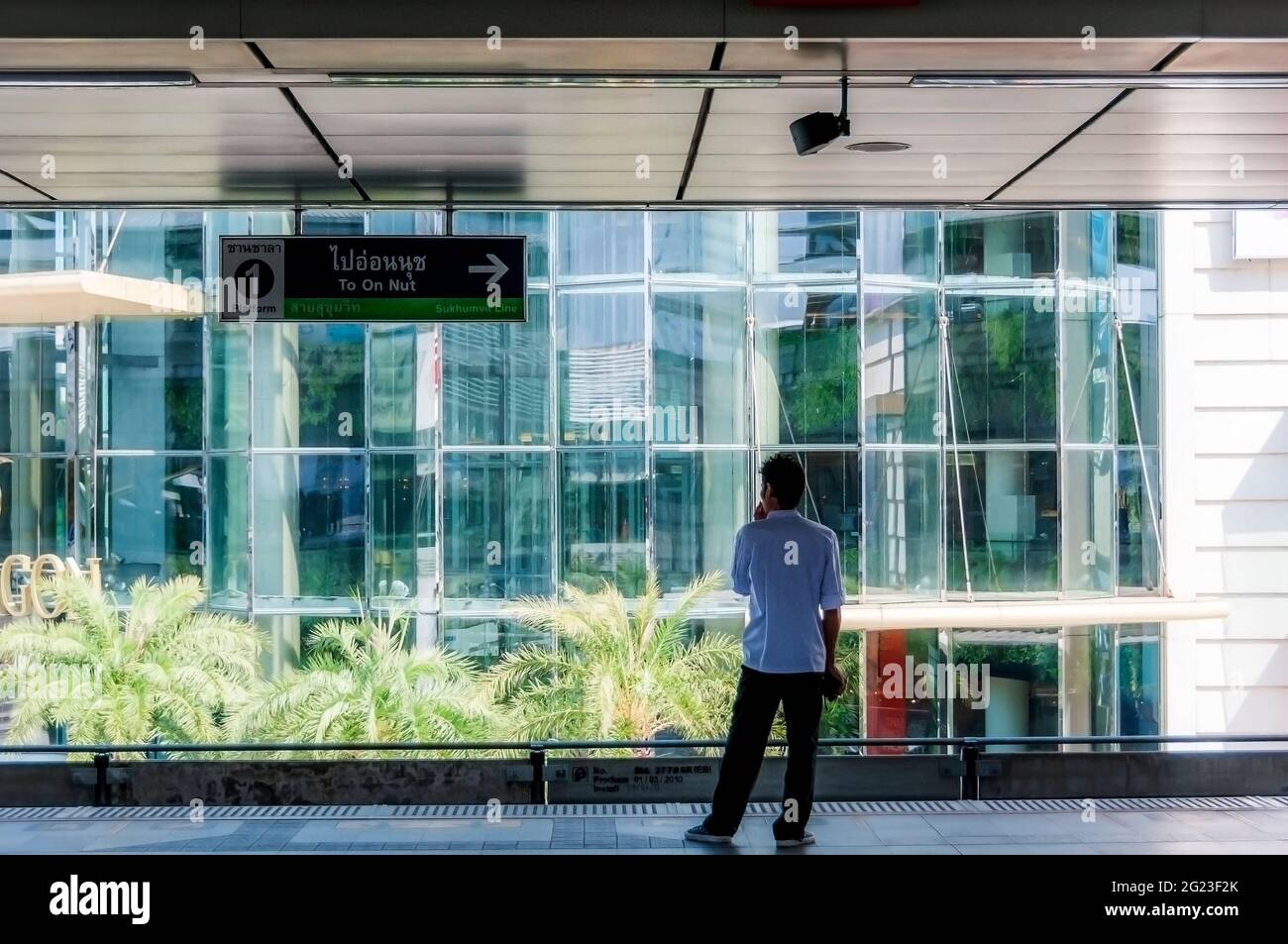 Un passeggero in piedi su un binario in attesa dell'arrivo di un treno sopraelevato BTS a Bangkok in Thailandia nel Sud Est Asiatico. Foto Stock