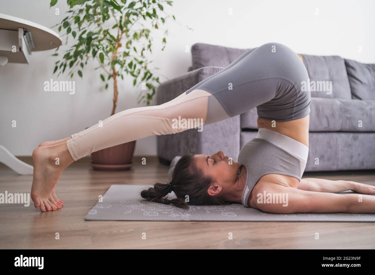 Giovane donna a praticare yoga, Halasana esercizio, aratro pongono Foto Stock