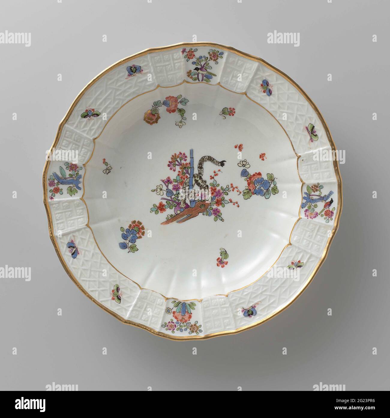 Tavola per zuppe, dipinta in modo multiplo con un decor kakiemon. Zuppa di porcellana dipinta. La piastra ha un bordo rigato e scalettato. La piastra è dipinta con una tigre, che ruota tra i fiori intorno a un gambo di bambù, blums Indiani sparsi, farfalle e rami con uccelli. Il bordo è decorato con il motivo 'Altbrandenstein'. La piastra è stata contrassegnata. Foto Stock