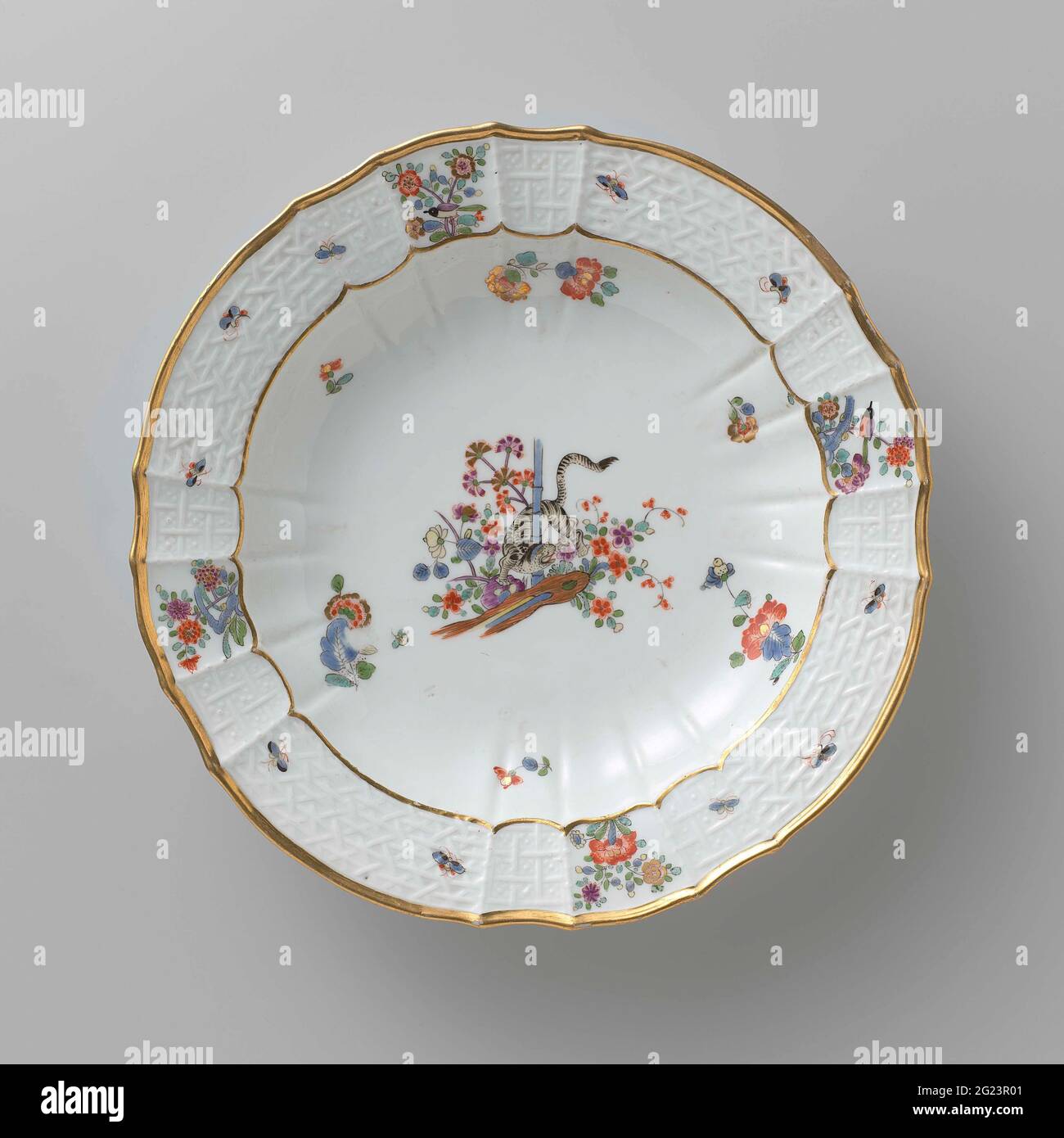 Tavola per zuppe, dipinta in modo multiplo con un decor kakiemon. Zuppa di porcellana dipinta. La piastra ha un bordo rigato e scalettato. La piastra è dipinta con una tigre, che ruota tra i fiori intorno a un gambo di bambù, blums Indiani sparsi, farfalle e rami con uccelli. Il bordo è decorato con il motivo 'Altbrandenstein'. La piastra è stata contrassegnata. Foto Stock