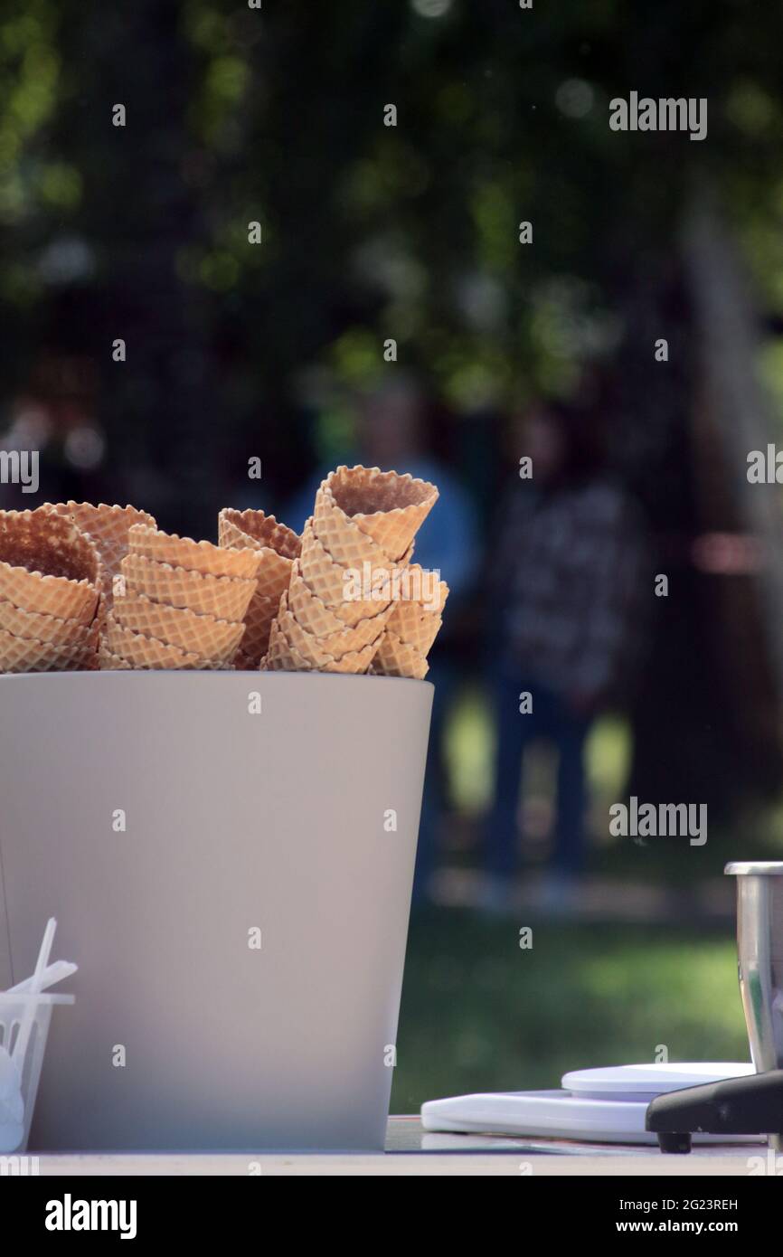 il concetto di mangiare fuori - un secchio di coni di waffle nel caffè estivo nel parco Foto Stock
