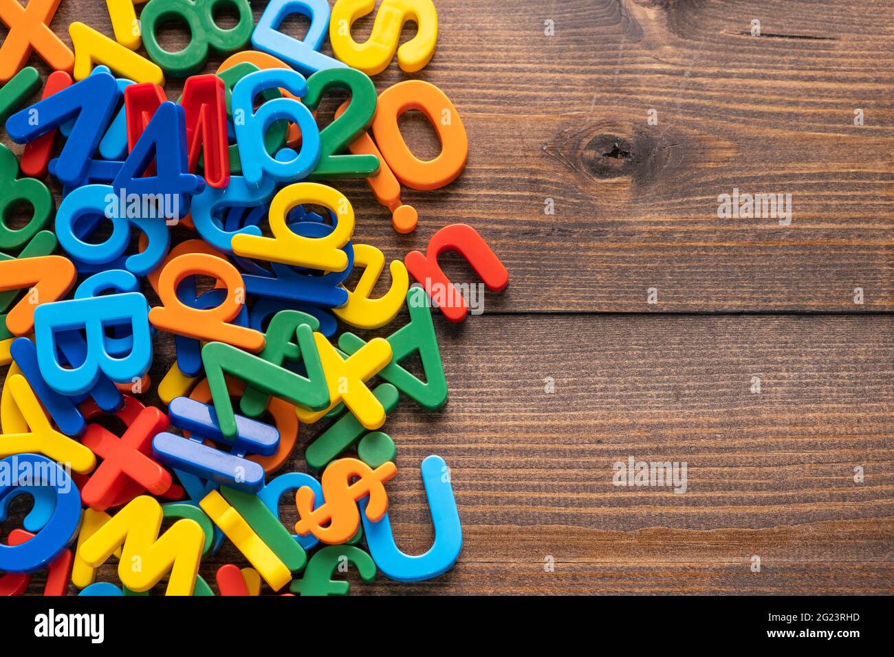 Vista dall'alto di lettere e numeri colorati in plastica su sfondo di legno Foto Stock