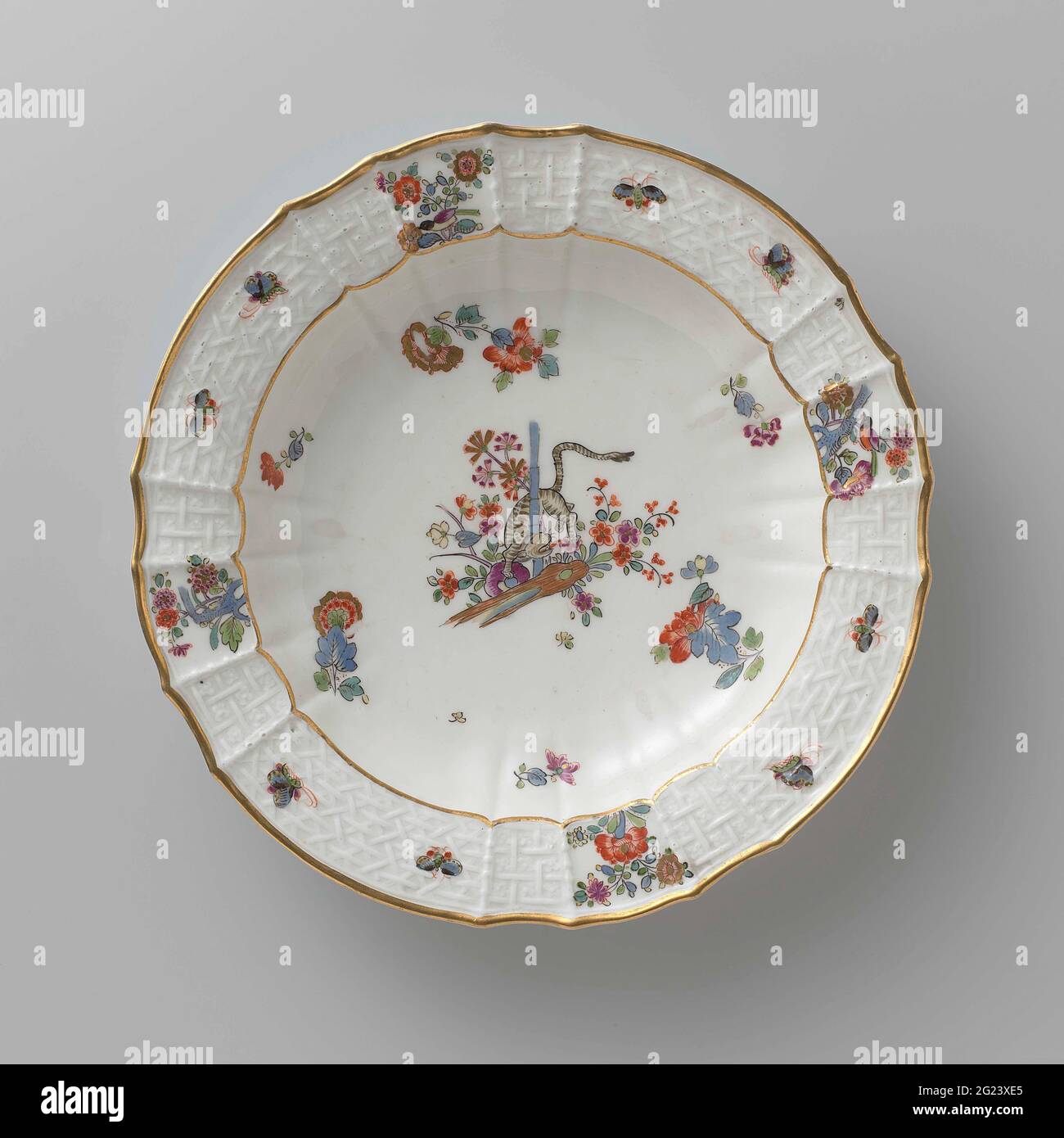 Tavola per zuppe, dipinta in modo multiplo con un decor kakiemon. Zuppa di porcellana dipinta. La piastra ha un bordo rigato e scalettato. La piastra è dipinta con una tigre, che ruota tra i fiori intorno a un gambo di bambù, blums Indiani sparsi, farfalle e rami con uccelli. Il bordo è decorato con il motivo 'Altbrandenstein'. La piastra è stata contrassegnata. Foto Stock