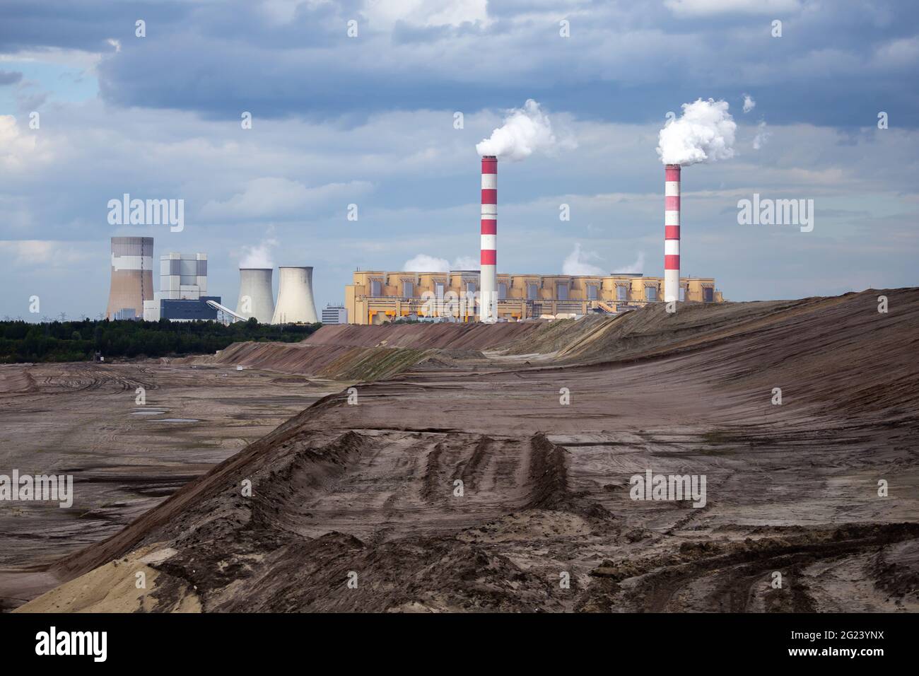 Vista di una centrale alimentata a lignite sullo sfondo di una miniera di carbone di opencast. Foto scattata di giorno. Un sacco di piccole nuvole nel cielo Foto Stock