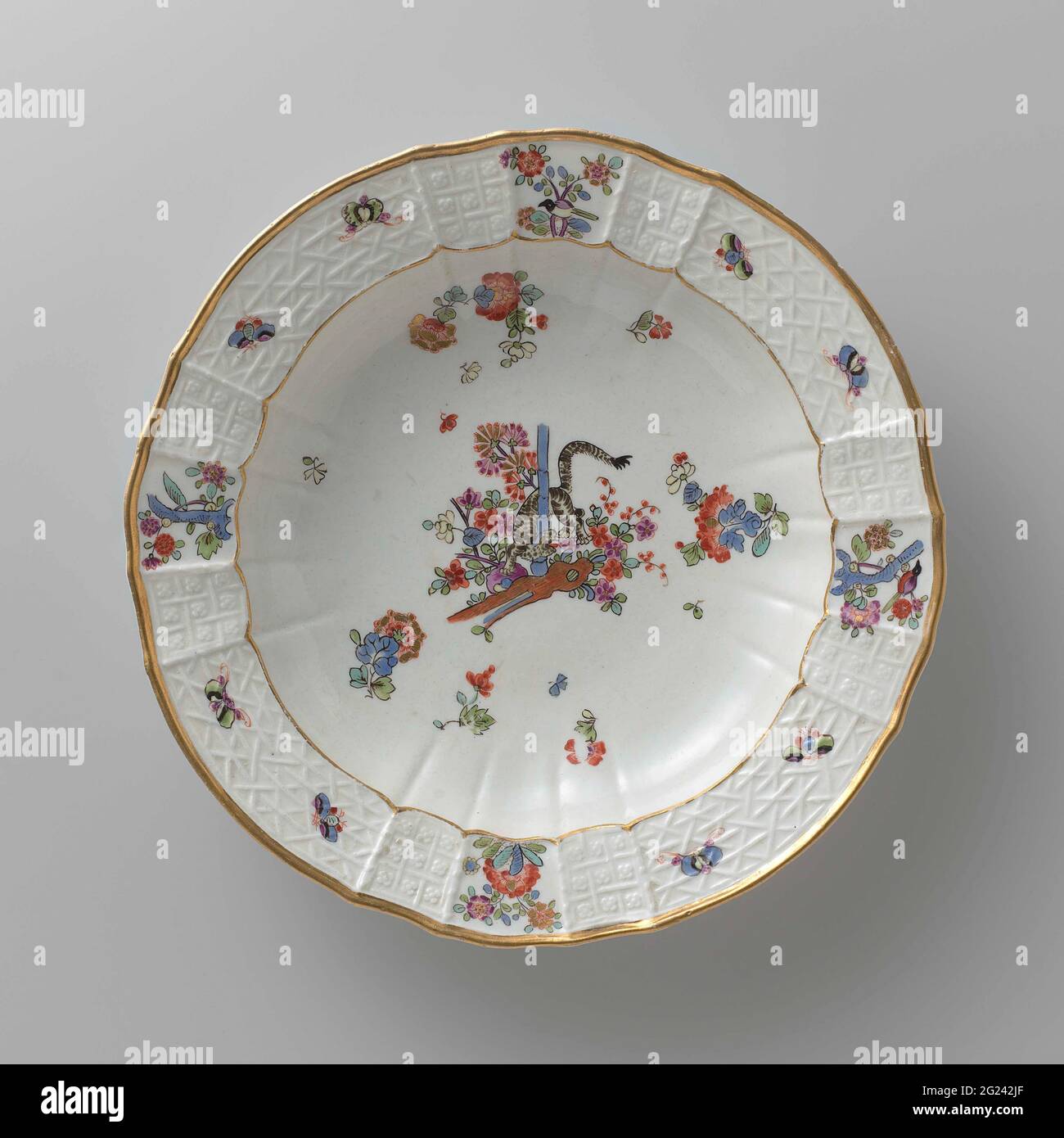 Tavola per zuppe, dipinta in modo multiplo con un decor kakiemon. Zuppa di porcellana dipinta. La piastra ha un bordo rigato e scalettato. La piastra è dipinta con una tigre, che ruota tra i fiori intorno a un gambo di bambù, blums Indiani sparsi, farfalle e rami con uccelli. Il bordo è decorato con il motivo 'Altbrandenstein'. La piastra è stata contrassegnata. Foto Stock