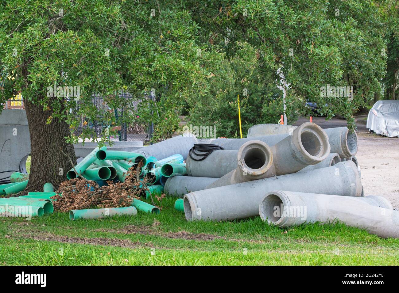 Pile di grandi tubi di drenaggio sul lato della strada nel quartiere Uptown di New Orleans Foto Stock