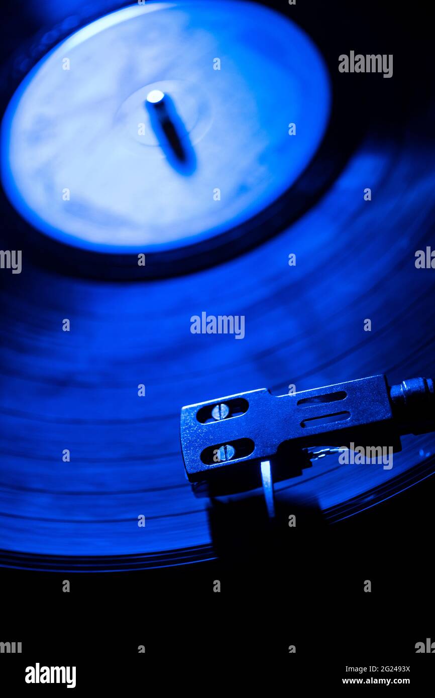 Primo piano di un ago del lettore di dischi in registrazione in luce blu Foto Stock