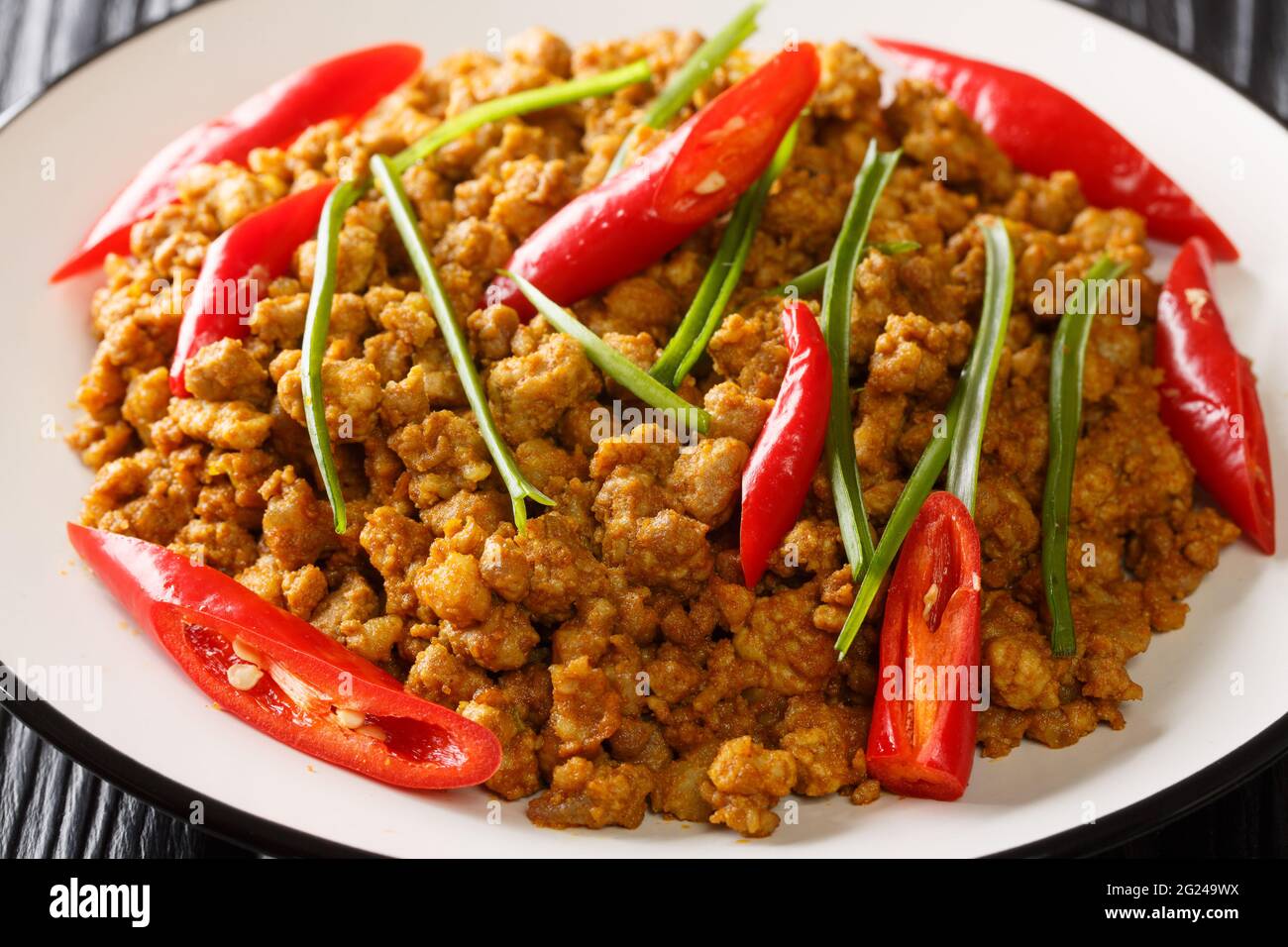 Sud tailandese Khua Kling curry di maiale primo piano nel piatto sul tavolo. Orizzontale Foto Stock