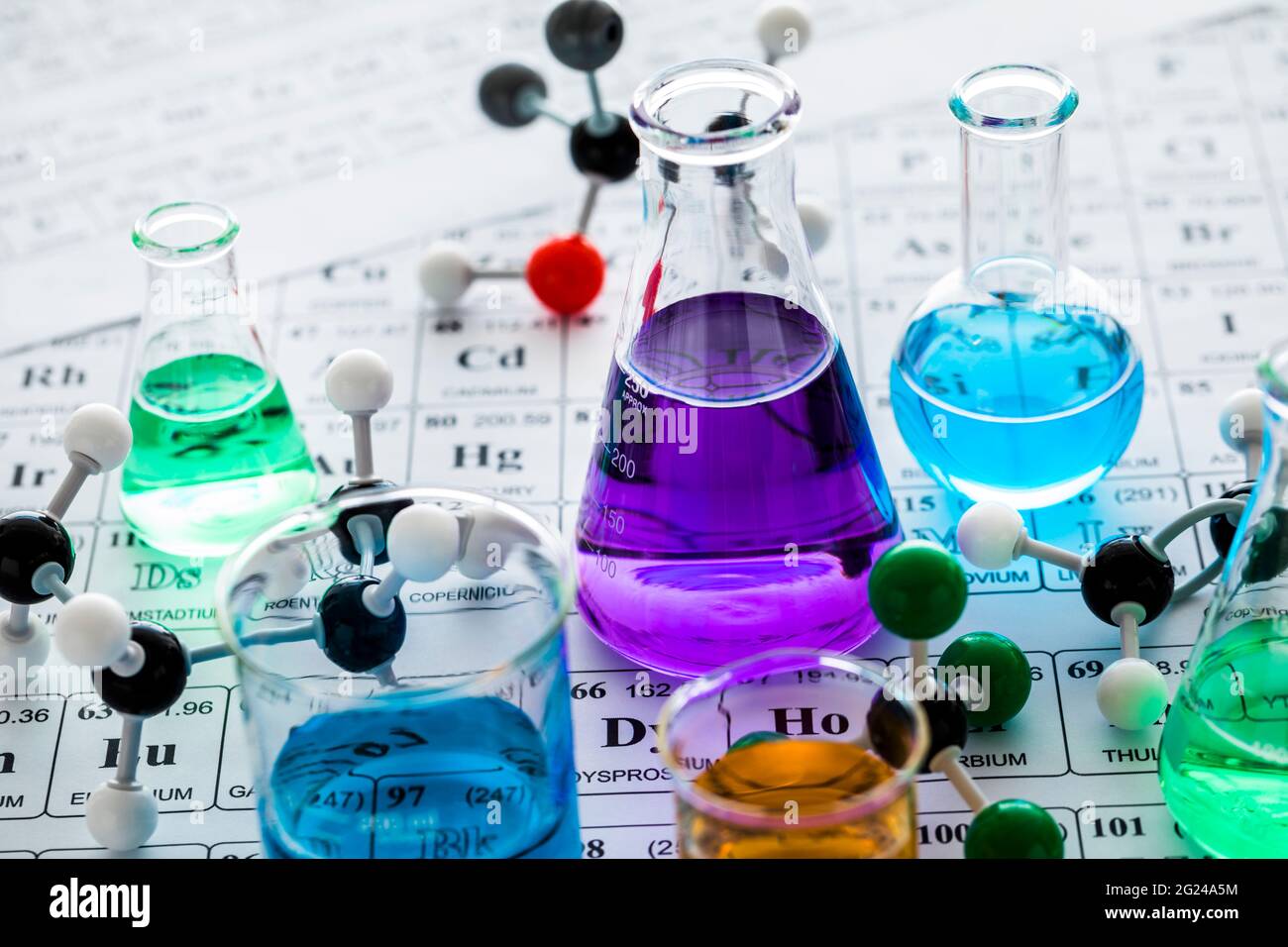 Modelli molecolari e vetreria da laboratorio con liquidi su tavola periodica Foto Stock