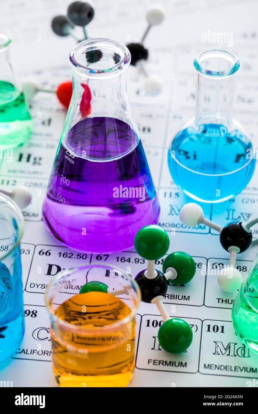 Modelli molecolari e vetreria da laboratorio con liquidi su tavola periodica Foto Stock