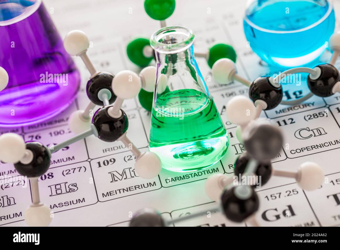 Modelli molecolari e vetreria da laboratorio con liquidi su tavola periodica Foto Stock