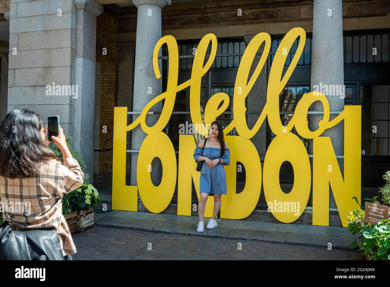 Londra, Regno Unito. 8 giugno 2021. Le donne scattano foto accanto a un cartello Hello London a Covent Garden. L'area ha subito una riduzione dei footfall a causa della pandemia in corso. I negozi locali e le aziende correlate sperano che il rilassamento delle restrizioni di blocco il 21 giugno porterà al ritorno dei turisti e degli acquirenti. Credit: Stephen Chung / Alamy Live News Foto Stock