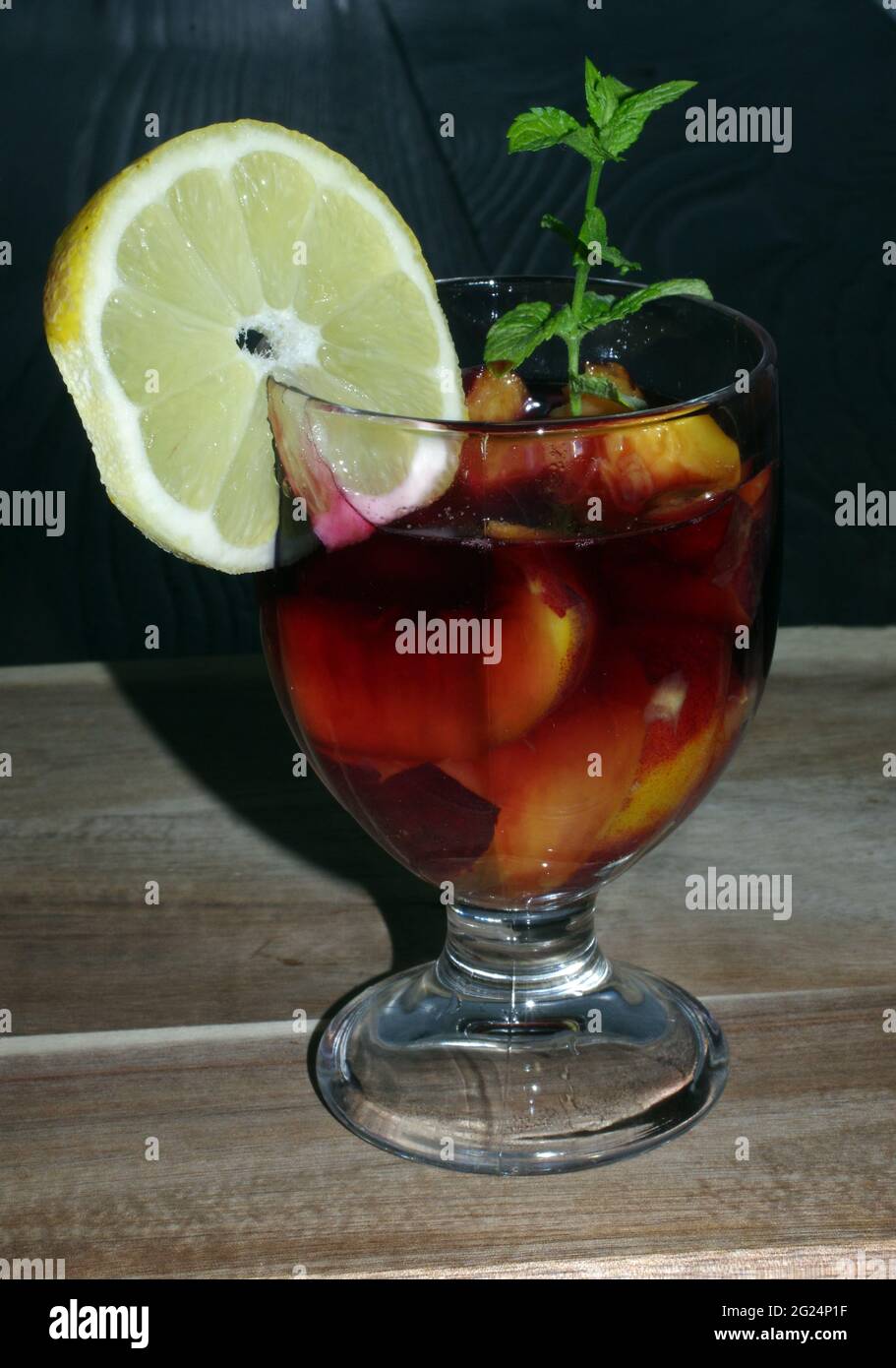 Pesche in vino rosso con foglie di limone e menta Foto Stock