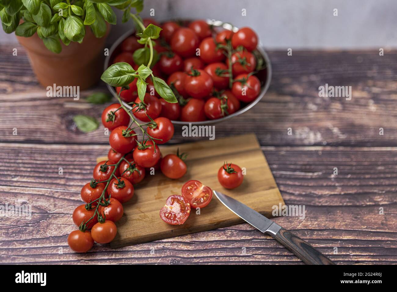frische, rote und reife Tomaten werden zubereitet, auf einen Holzbrett kleingeschnitten. Pomodori freschi, rossi e maturi sono preparati, tagliati in pi piccolo Foto Stock