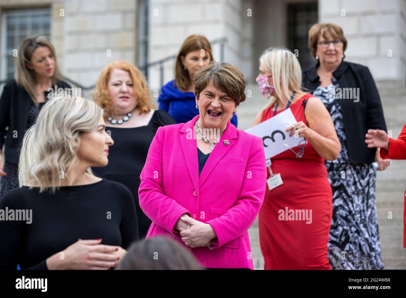 L'ex leader del DUP Arlene Foster (blazer rosa) interagisce con gli MLA durante una fotocellula per gli MLA femminili sui gradini degli edifici del Parlamento a Stormont. Foto Stock