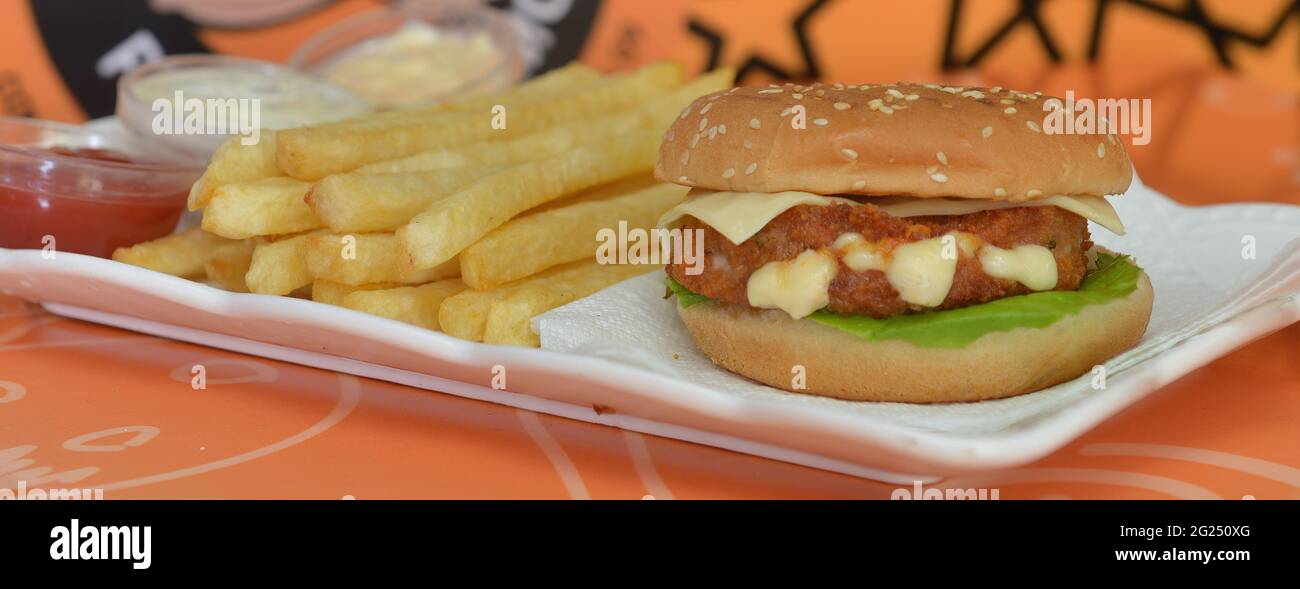 vista dall'alto delle patatine fritte con un delizioso vassoio di hamburger al pollo e salse assortite Foto Stock