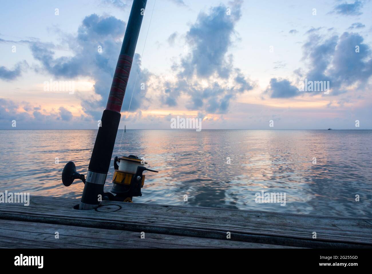 Un'asta di sollevamento e una bobina sono puntati su su un molo a Fairhope, Alabama, come il sole tramonta il 7 giugno 2021. Foto Stock