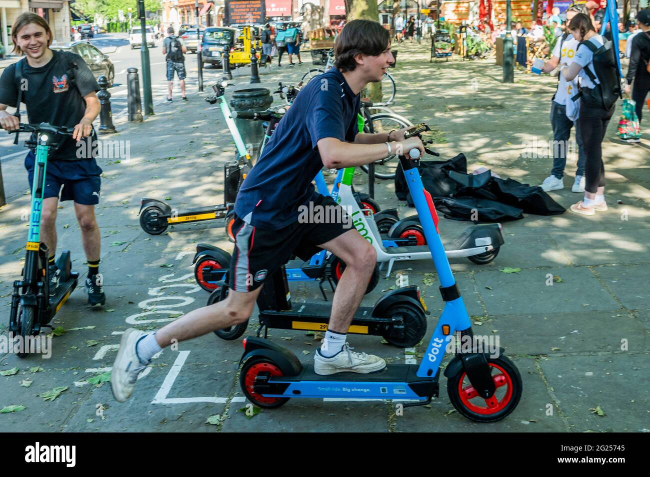 Londra, Regno Unito. 8 Jun 2021. Molti sembrano trovare il processo di sblocco abbastanza difficile ma una volta che ottengono andare sembrano abbastanza felici - gli scooter elettrici (e-scooter) ora sono disponibili per affittare in un piccolo numero di quartieri di Londra. Questo è l'unico modo per guidare legalmente un e-scooter su strade pubbliche o in altri luoghi pubblici di Londra. Il noleggio e-scooter è fornito da tre operatori diversi: Dott., Lime e TIER. Per noleggiare un e-scooter gli utenti devono: Scaricare l'app dell'operatore prescelto; completare la procedura di registrazione, compresa la verifica dell'età e della patente di guida; e completare la mand Foto Stock