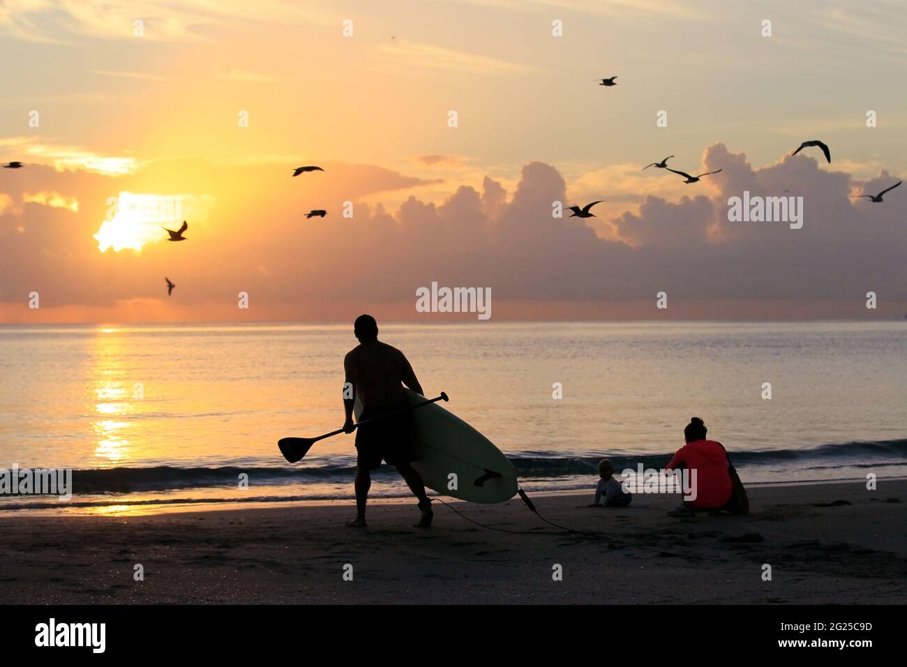 Miami-Sunny Isles-USA- 2-01-2016- Un uomo cammina con la sua tavola da surf in acqua sulla spiaggia Sunny Isles. © JOSE ISAAC BULA URRUITA. Foto Stock