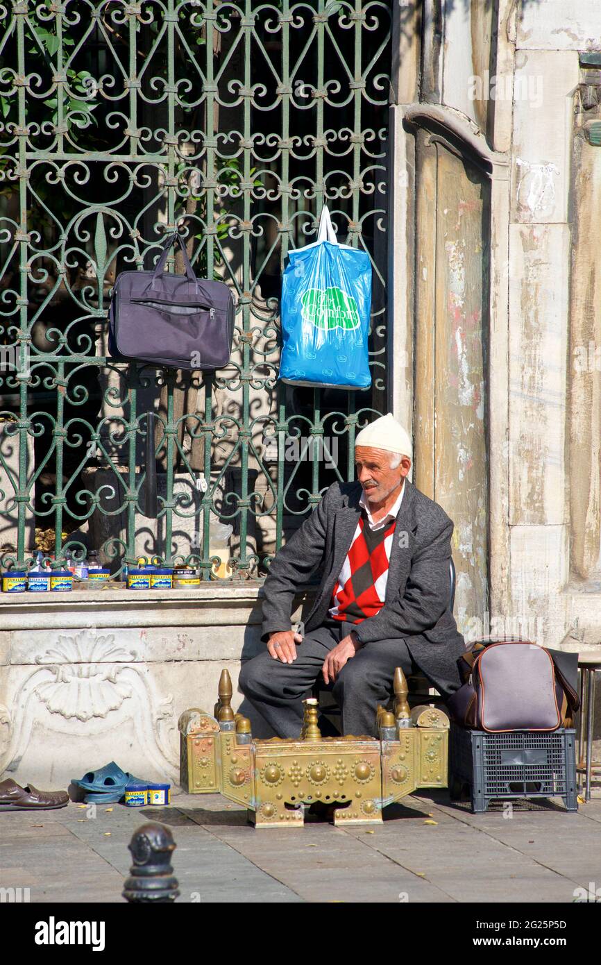 Uomo turco che offre pulizia delle scarpe e lucidascarpe, centro di Istanbul, Turchia Foto Stock