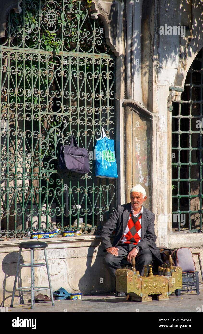 Uomo turco che offre pulizia delle scarpe e lucidascarpe, centro di Istanbul, Turchia Foto Stock