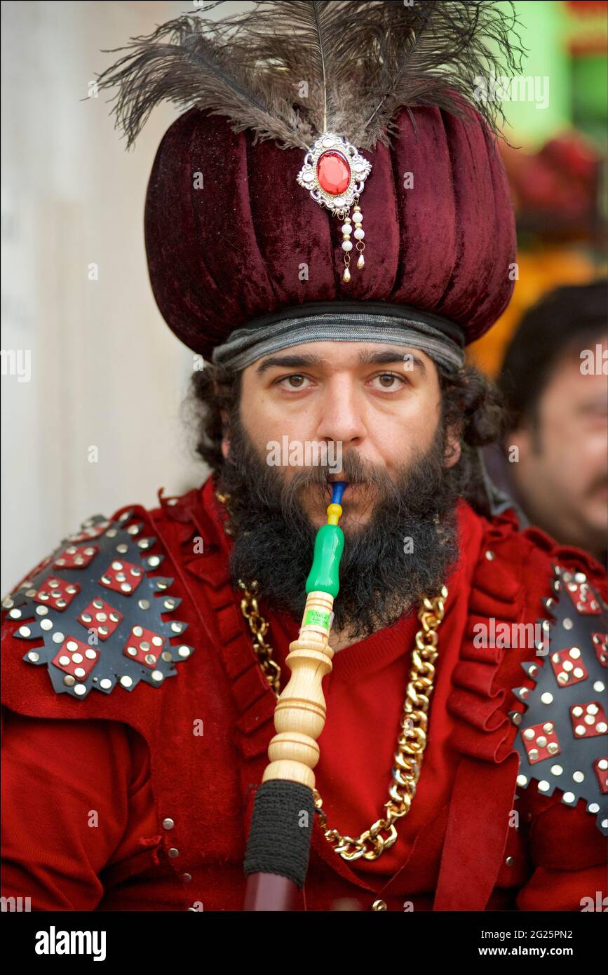 Uomo turco che indossava un abito ottomano e fuma un tubo di hookah, Istanbul, Turchia Foto Stock