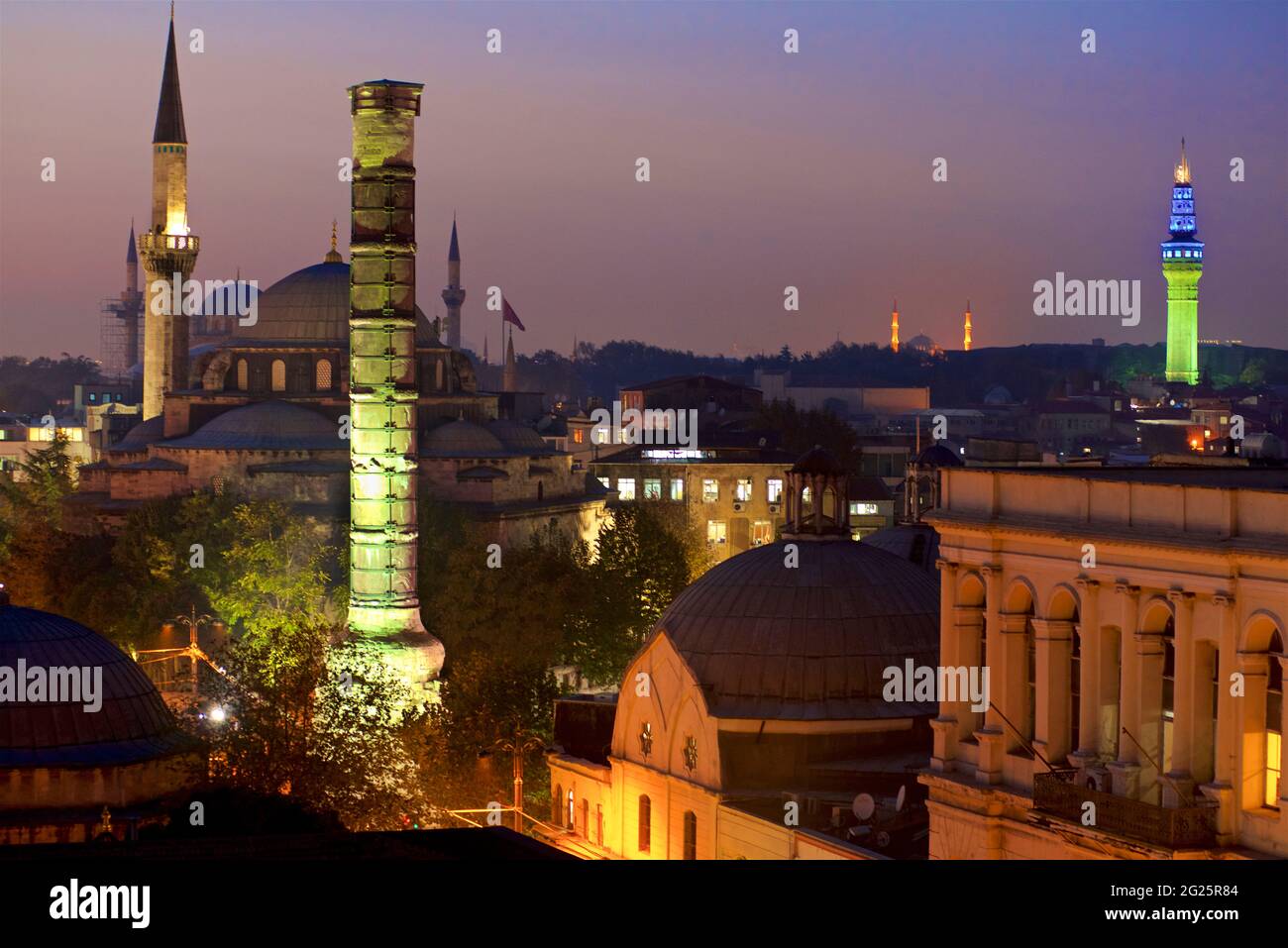 Colonna di Costantino illuminata al crepuscolo, con la Santa Sofia oltre. Istanbul, Turchia Foto Stock