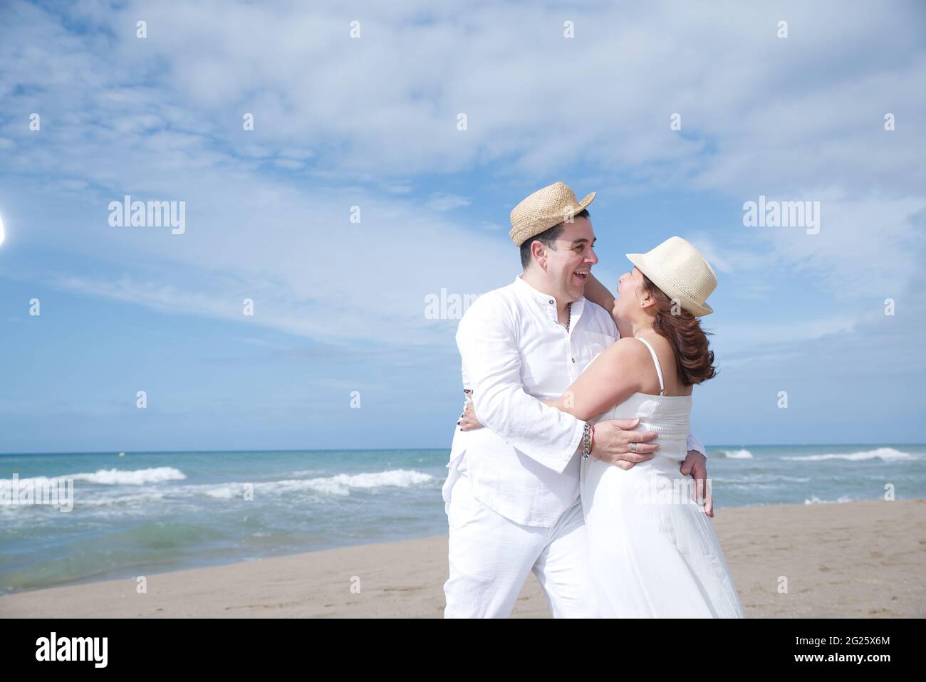 Coppia innamorata, uomo ispanico con donna latina, a piedi sulla spiaggia. Foto Stock