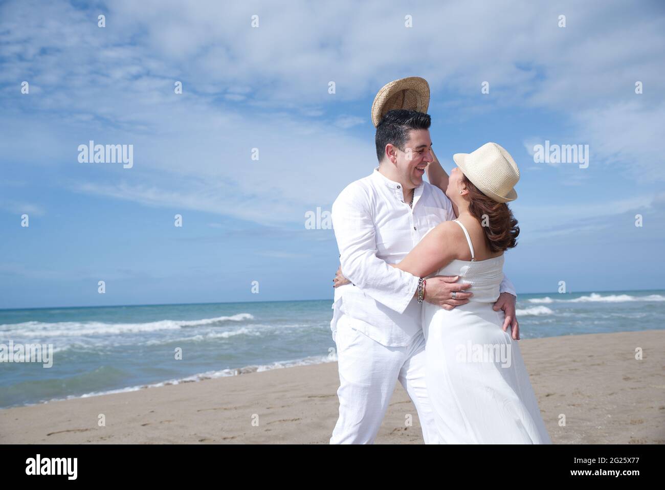 Coppia innamorata, uomo ispanico con donna latina, a piedi sulla spiaggia. Foto Stock