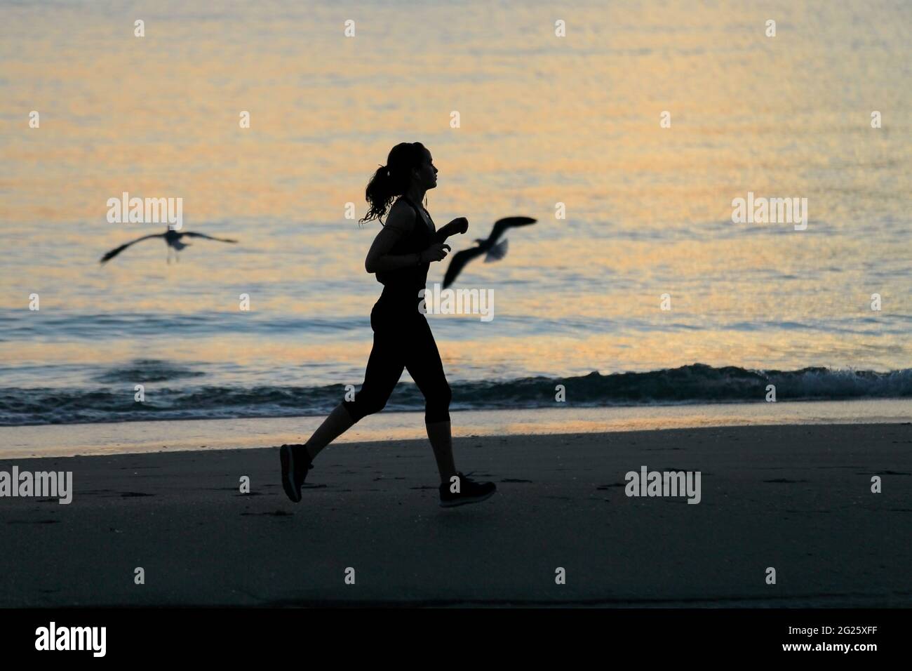 Miami-Sunny Isles-USA- 2-01-2016- una ragazza corre all'alba alla spiaggia Sunny Isles a Miami.FL. © JOSE ISAAC BULA URRUITA. Foto Stock