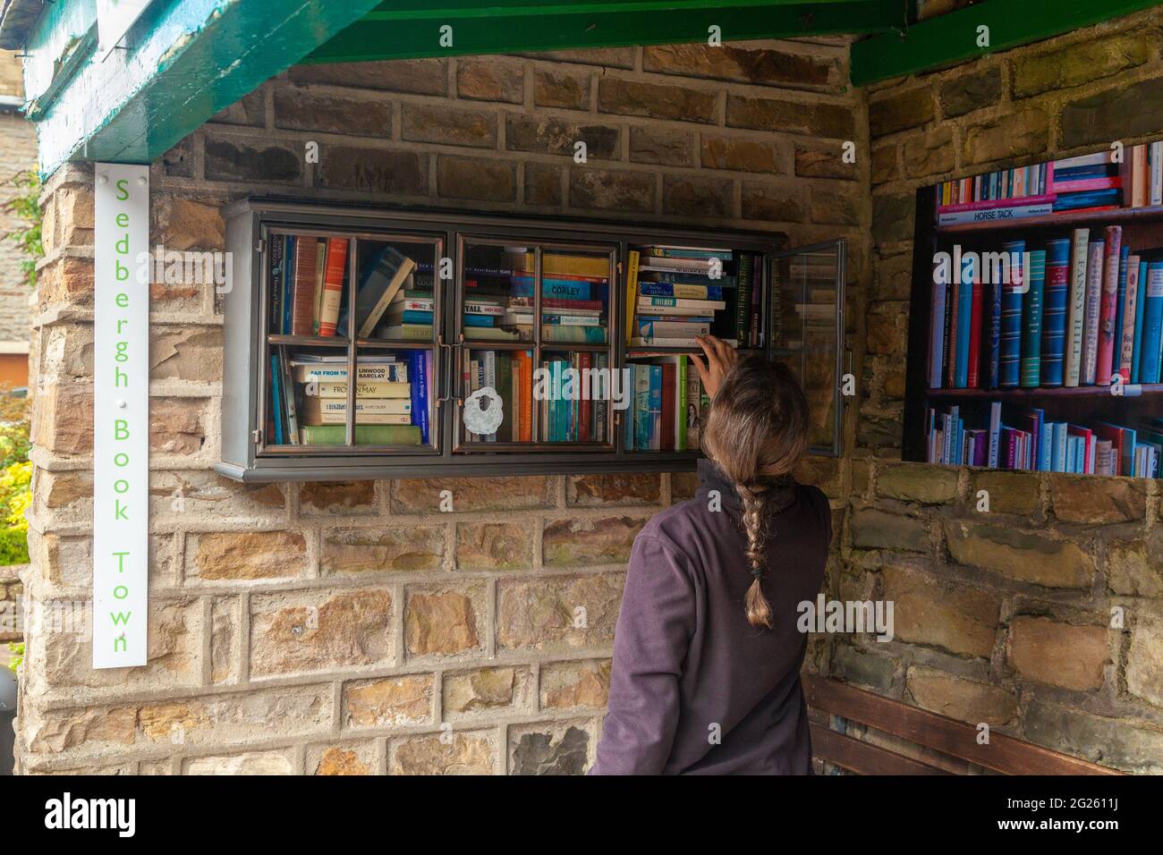 Sedbergh, Main Street, persona nel magazzino dei libri in una ex fermata dell'autobus Foto Stock