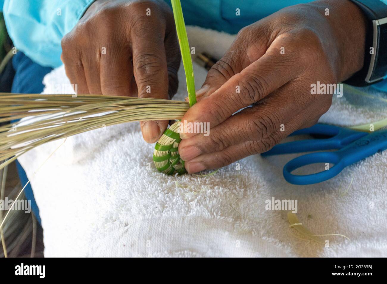 Discendente di schiavi, questa donna Gullah Geechee maestro tessitore di canestro d'erba dolce crea arte culturale tradizionale sull'isola di Sapelo, Georgia. Foto Stock