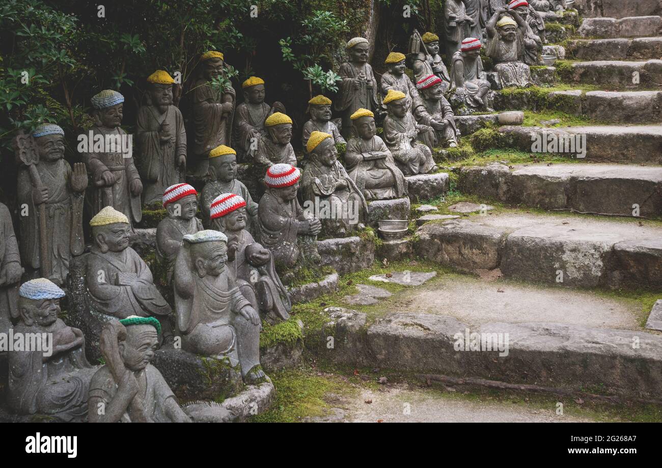 Statue di Buddha con colorate offerte di cappelli lavorati a maglia lungo le scale che rappresentano i primi 500 discepoli dello storico Buddha Shakyamuni al tempio Foto Stock