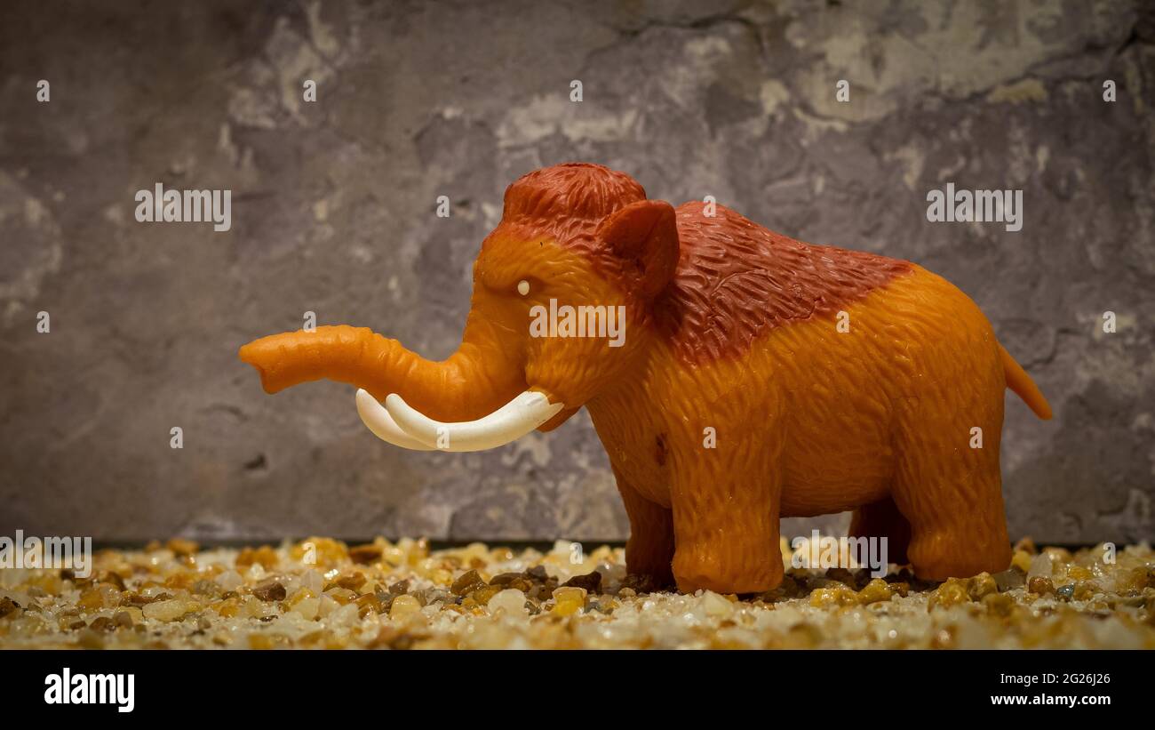 mammut giocattolo su sfondo roccioso Foto Stock