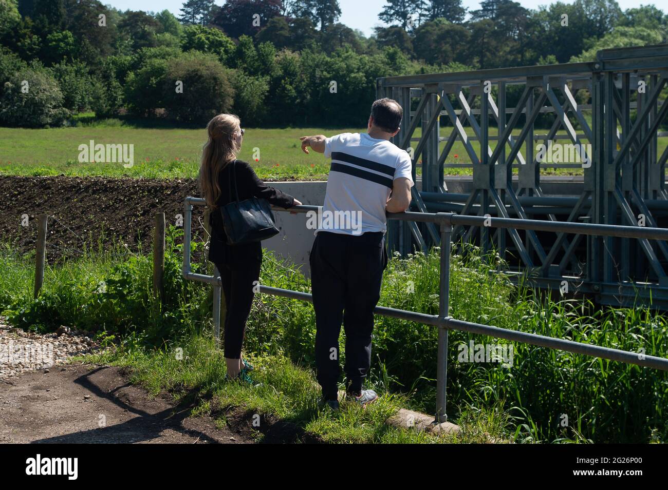 Chalfont St Giles, Regno Unito. 5 Giugno 2021. Sian Berry (a sinistra) il Co-leader del Green Party ha incontrato oggi i residenti locali colpiti dalla costruzione della ferrovia ad alta velocità. Qui guarda il fiume Misbourne che è stato inondato più del solito come HS2 hanno rimosso alberi e siepi vicino ad esso. HS2 hanno costruito una strada di trasporto ripida e di alto lato a destra fuori le case residenti in Bottom House Farm Lane, Chalfont St Giles. Gli HS2 stanno costruendo un albero di sfiato dal tunnel che stanno alesando sotto i Chilterns e gli HGV stanno portando il calcestruzzo affinchè esso sia versato nell'albero di sfiato. Credito: Maureen McLean/Ala Foto Stock