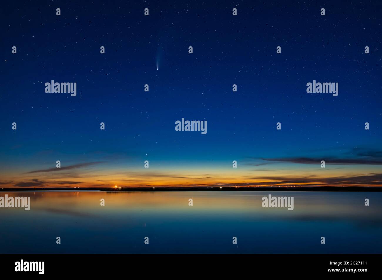 Comet NEOWISE nel cielo crepuscolo sulle acque ancora di crawling Lake, Alberta, Canada. Foto Stock