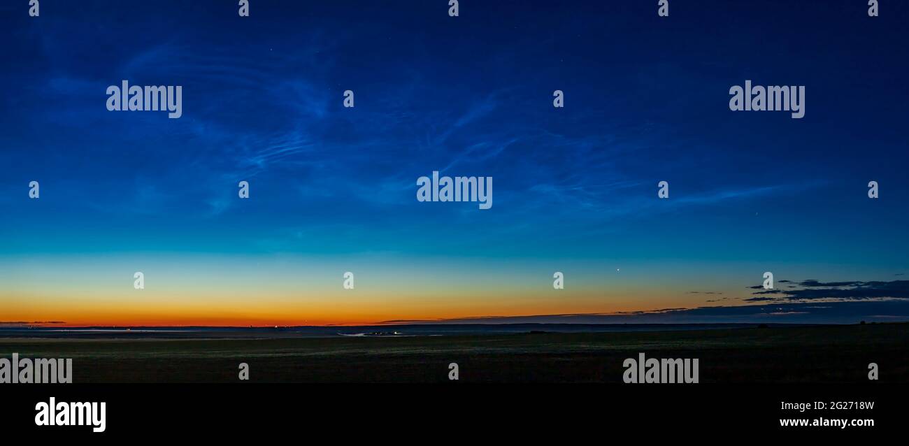 Cometa NEOWISE che sorge nel nord-est nel cielo dell'alba con nubi noctilucenti, Alberta, Canada. Foto Stock
