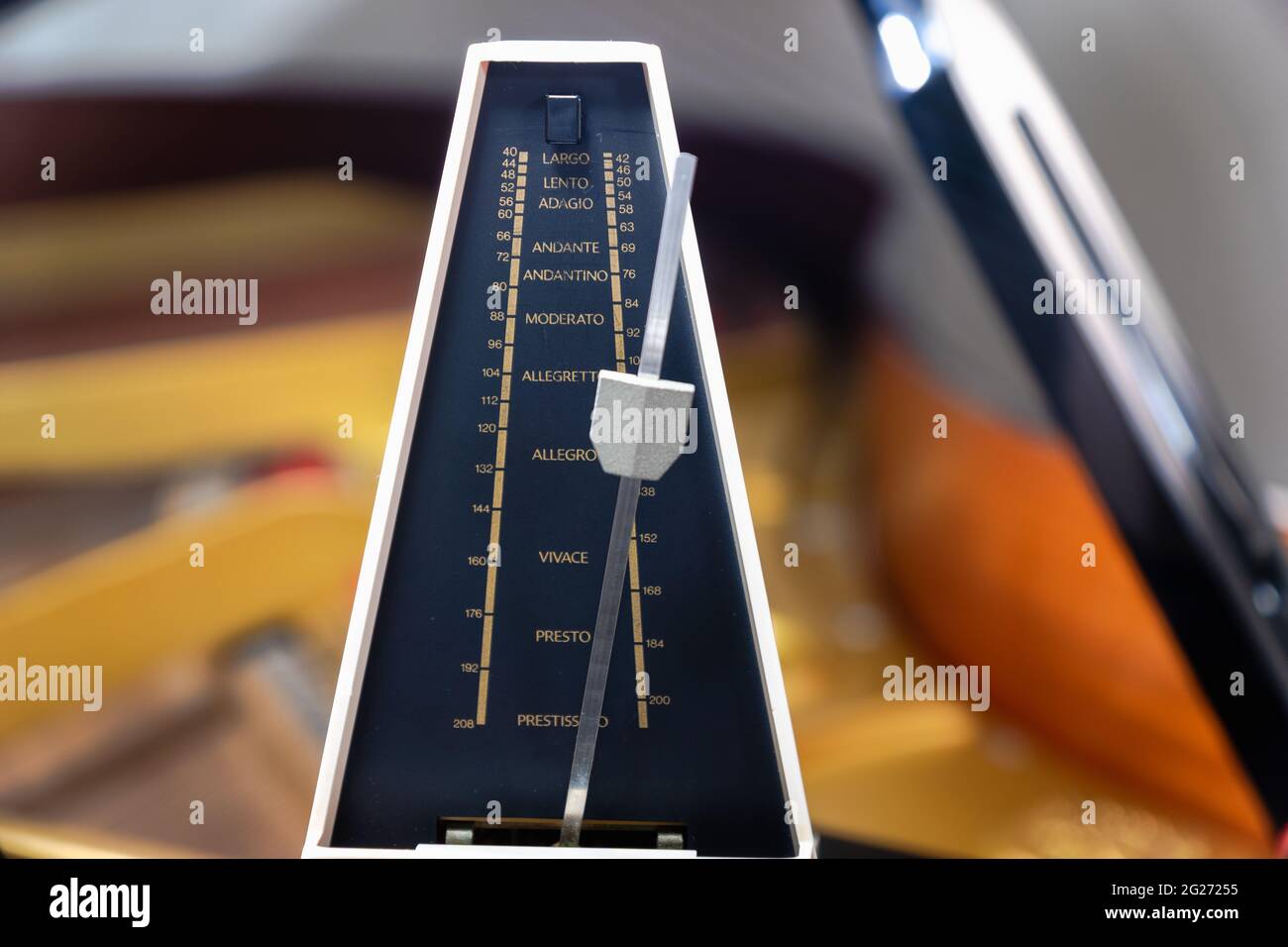 Metronomo con pendolo per mantenere il ritmo e il tempo per pianoforte, musica classica, musicisti - primo piano con messa a fuoco selettiva Foto Stock