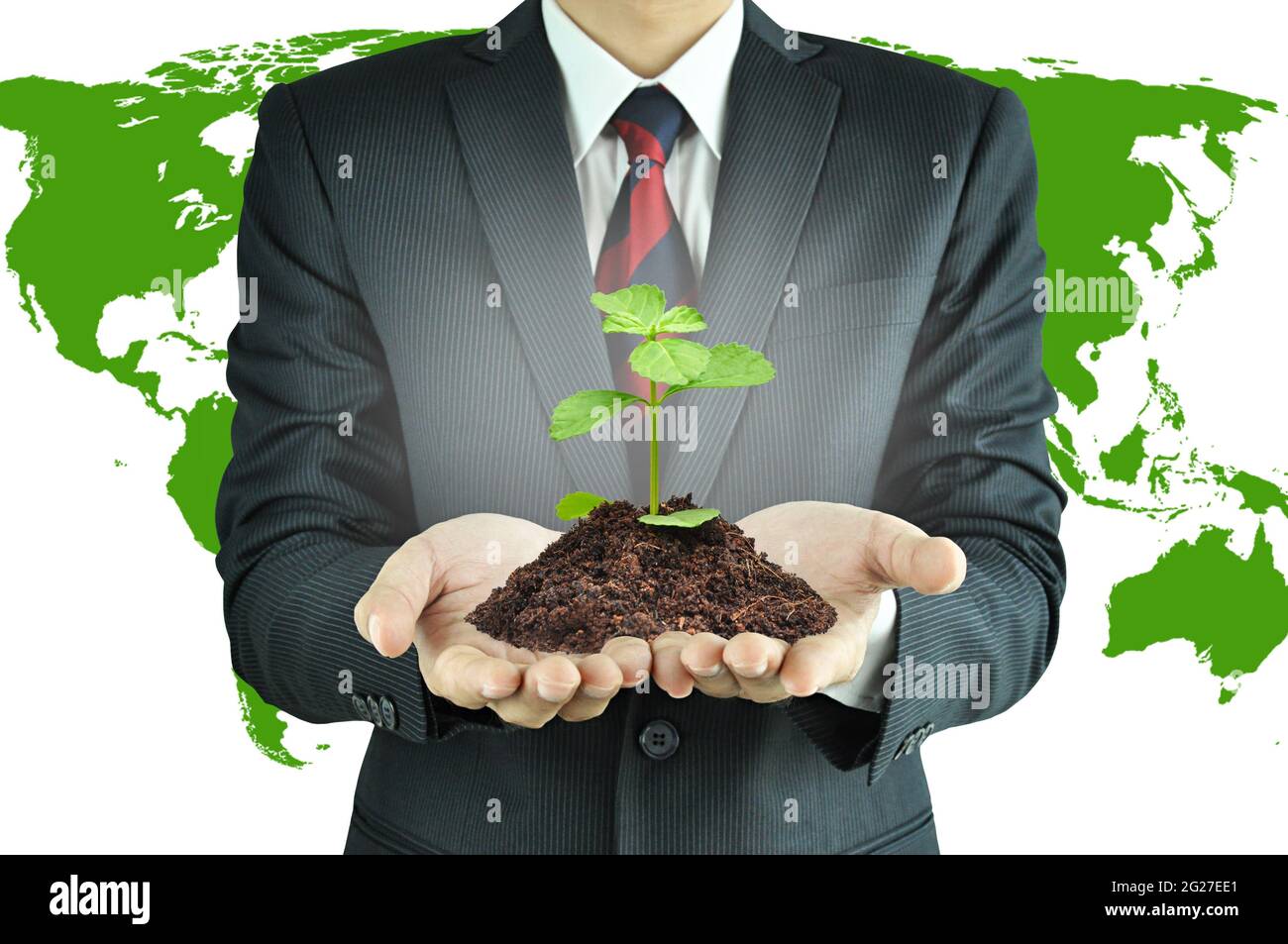 Uomo d'affari che tiene verde semenzatura con suolo - sviluppo sostenibile & concetto di conservazione Foto Stock