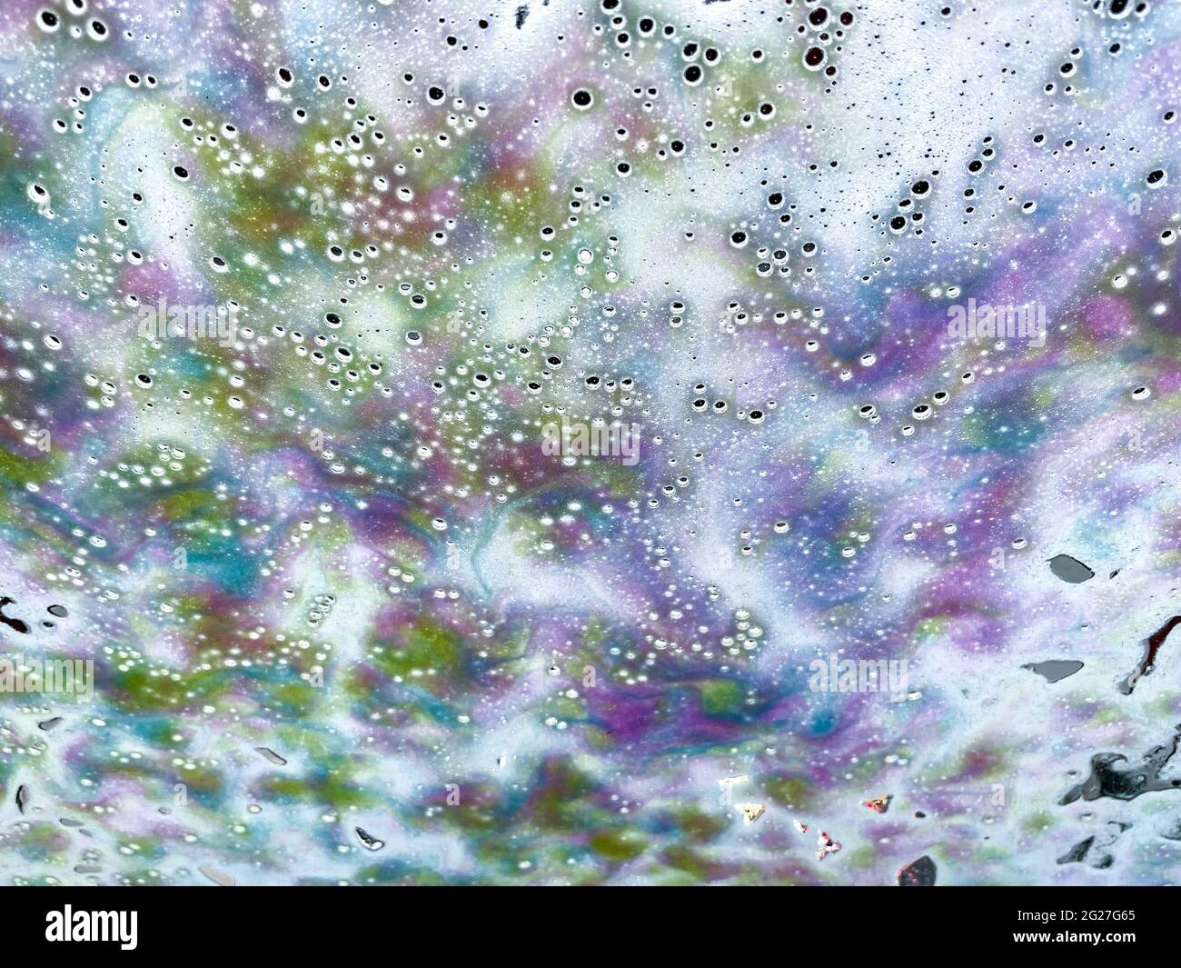 Arte astratta trama sfondo di un autolavaggio automatico che mostra sapone suds e acqua di risciacquo modelli e disegni sul parabrezza di un veicolo Foto Stock