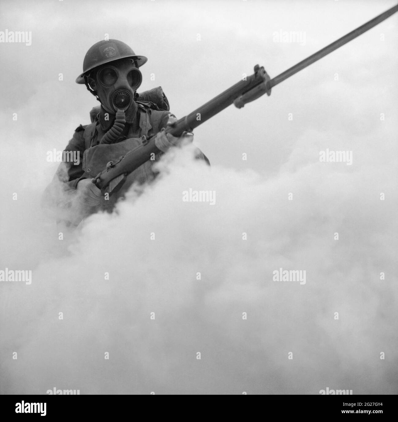 Soldato britannico che avanza attraverso un fumo-schermo con fucile bayoneted durante la seconda guerra mondiale. Foto Stock