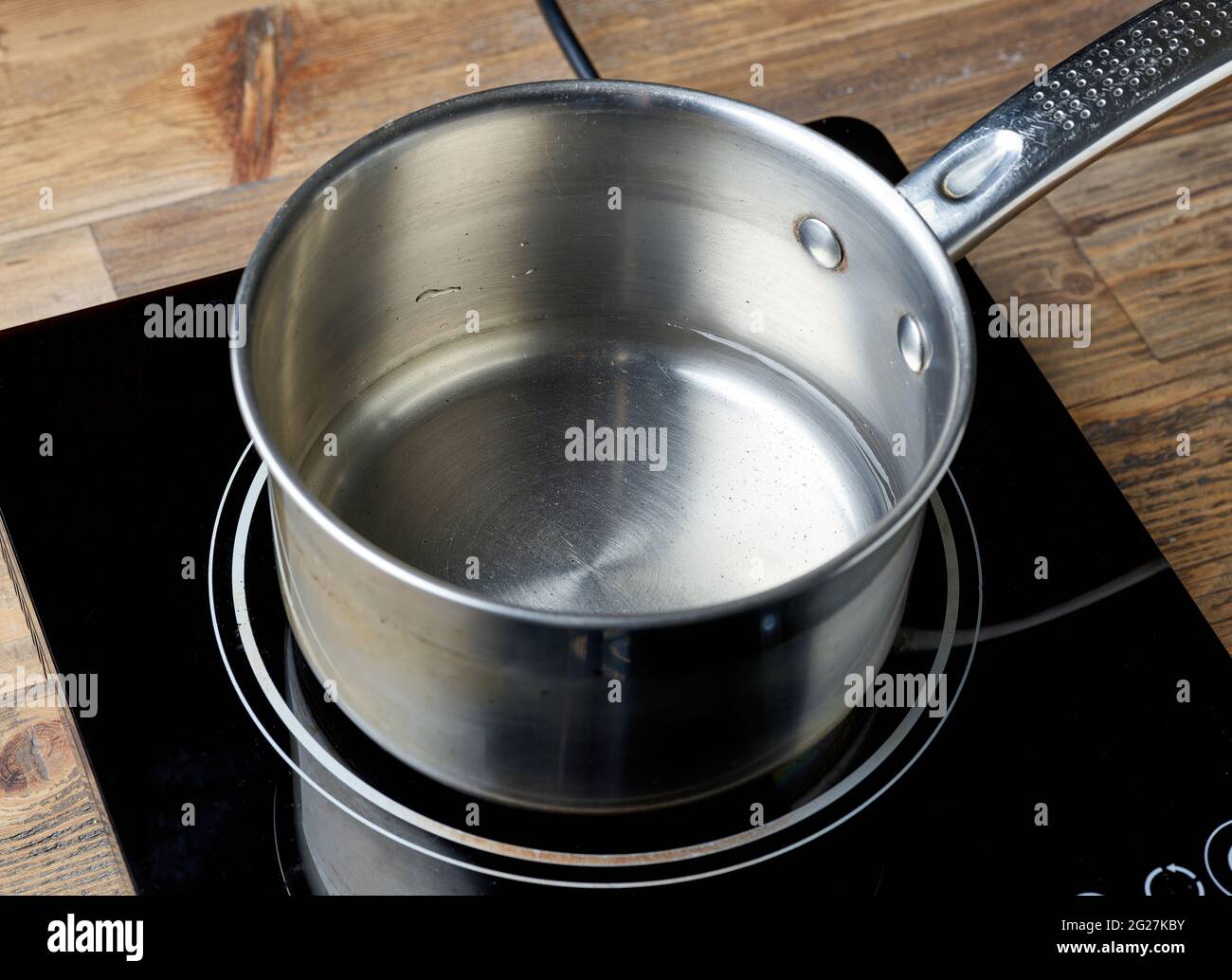 bollitore d'acqua su piano cottura elettrico a induzione su tavolo da  cucina in legno Foto stock - Alamy